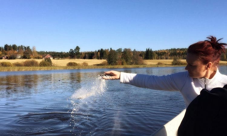 A lady Scattering Cremation Ashes in the river